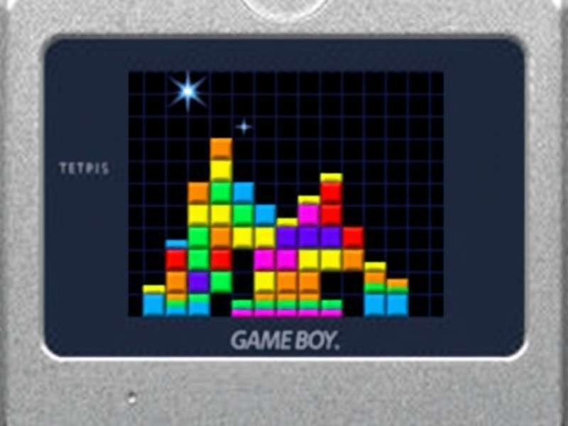 Vintage Nintendo Game Boy playing Tetris on a wooden table